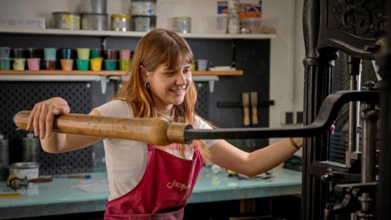 Janka Kocisek operating a printing press at the University of Applied Arts Vienna